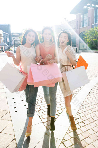 阳光下时尚的年轻女孩们购物逛街相伴清晰图片