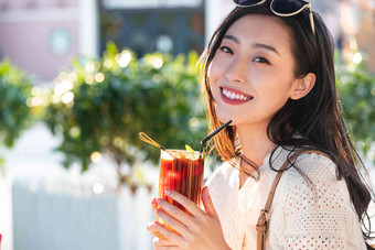 快乐的青年女人拿着夏日饮品