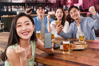 青年朋友在酒吧喝酒玩手机吃饭影相