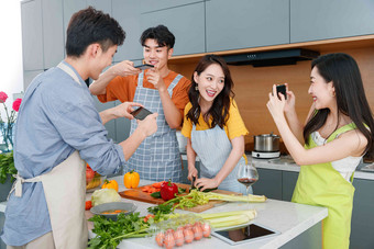 快乐的年轻人在厨房做饭照相