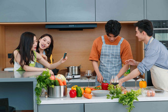 快乐的年轻人在厨房做饭照相社交高端相片