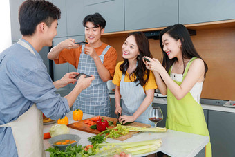 快乐的年轻人在厨房做饭照相快乐高清图片