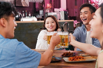 喝啤酒的快乐年轻人两对男女一起约会清晰照片