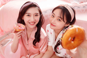 拿着甜甜圈的漂亮年轻闺蜜亚洲人高清图片