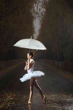 拿着雨伞的青年女人跳芭蕾舞