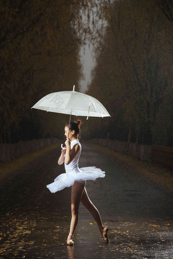 拿着雨伞的青年女人跳芭蕾舞湿高质量摄影图