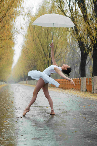 拿着雨伞的青年女人跳芭蕾舞