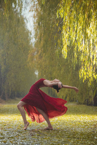 穿红色裙子的青年女人在<strong>户外</strong>跳芭蕾舞<strong>道路</strong>写实素材