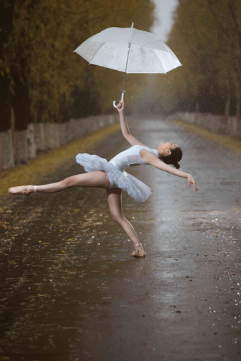 拿着雨伞的青年女人跳芭蕾舞