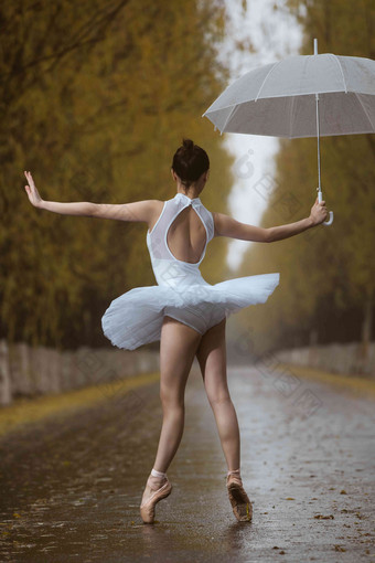 拿着雨伞的青年女人跳芭蕾舞
