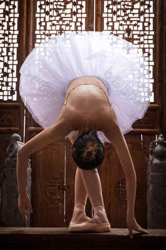 青年女人在<strong>中式古典</strong>门前跳芭蕾舞