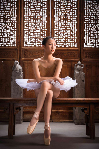 芭蕾舞演员坐在中式古典门前