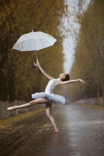 拿着雨伞的青年女人跳芭蕾舞