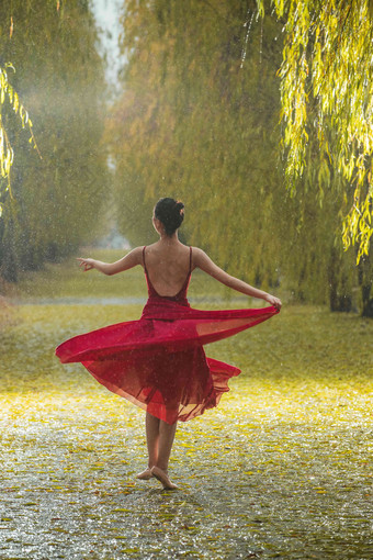 穿红色裙子的青年女人在户外跳<strong>芭蕾舞</strong>下雨氛围影相