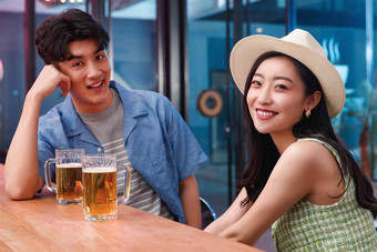 青年情侣在酒吧喝酒啤酒杯高清相片