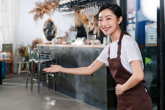 咖啡店门口迎接顾客的女服务员做手势高清素材