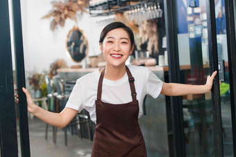 咖啡店门口迎接顾客的女服务员