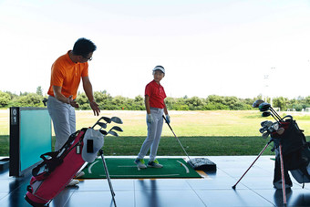 练习场上教练指导儿童打高尔夫