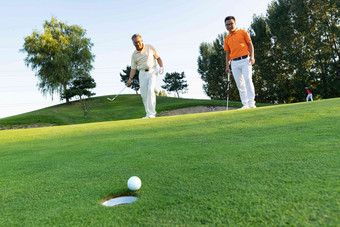 青年人和老年人打高尔夫仅男人场景