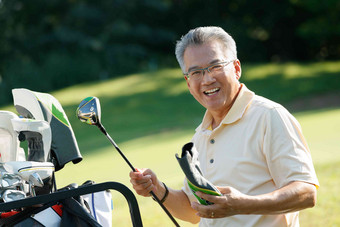 快乐的老年人拿着高尔夫球杆仅男人清晰相片