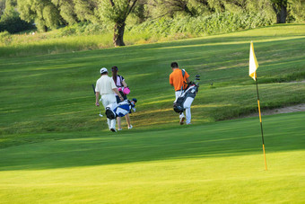 高尔夫球场上青年人和老年人一起步行的背影交流清晰摄影