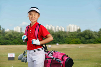 户外快乐儿童背着高尔夫球包蓝天高端场景