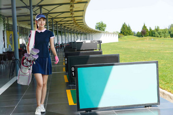 自信的青年女人背着高尔夫球包在练习场行走自信清晰素材