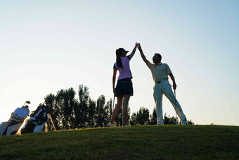 高尔夫球场上青年女人和老年人庆祝<strong>击掌</strong>