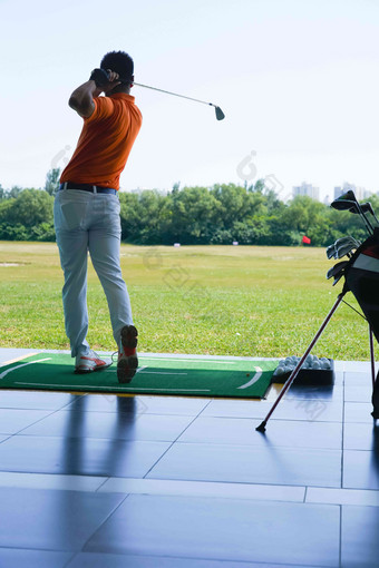 高尔夫练习场上青年男人打高尔夫背影高质量场景