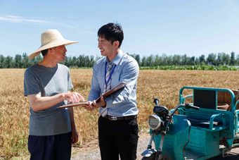 科研人员和<strong>农民</strong>在麦田旁交流