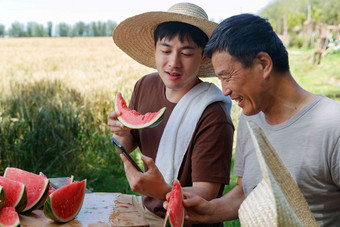 农民在田地旁休息吃西瓜