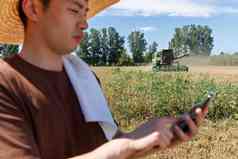 农民站在麦田里使用手机