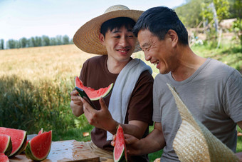 农民在田地旁休息吃西瓜