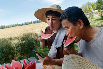 农民在田地旁休息吃西瓜白昼清晰拍摄