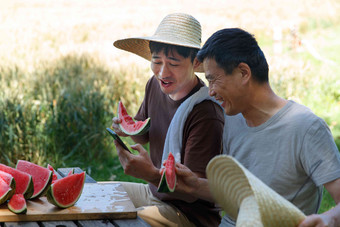 农民在田地旁休息吃西瓜