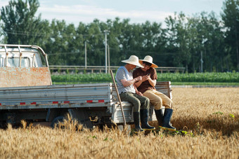 坐在车上使用手机的农民