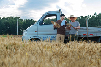 靠在车上休息聊天的农民收获高质量摄影图