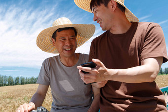 农民坐在三轮车上使用手机微笑氛围相片