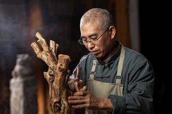 在树根上认真雕刻的工匠师中国元素清晰镜头