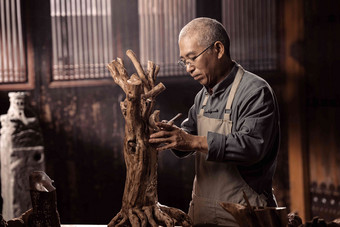 在树根上认真雕刻的工匠师木匠写实拍摄