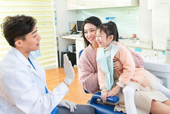 年轻妈妈带着小女孩看牙医