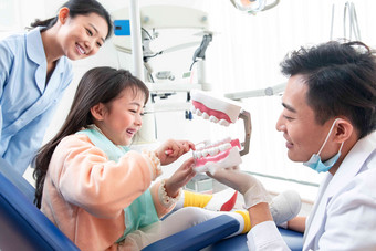 牙科医生教小女孩刷牙男人氛围相片