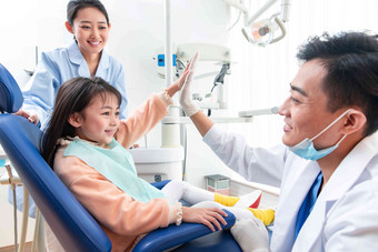 牙科医生给小女孩治疗关爱摄影图