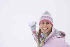 肖像快乐年轻的女人扔雪球冬天