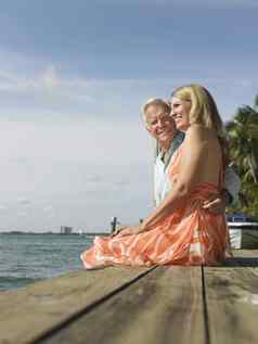 一边视图中间岁的夫妇坐着边缘码头