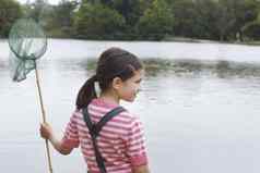 后视图年轻的女孩持有钓鱼网湖