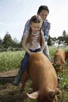微笑父亲帮助女儿骑猪圈天空