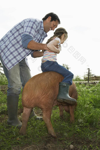 完整的长度快乐<strong>父亲帮助</strong>女儿骑猪圈