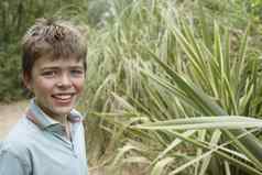 特写镜头肖像微笑年轻的男孩户外植物