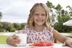 肖像微笑女孩坐着户外表格西瓜玻璃牛奶